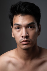 Asian man portrait with no makeup show his real skin in grey background - soft focus