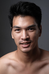 Asian man portrait with no makeup show his real skin in grey background - soft focus