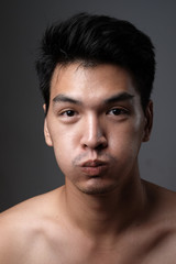 Fototapeta premium Asian man portrait with no makeup show his real skin in grey background - soft focus