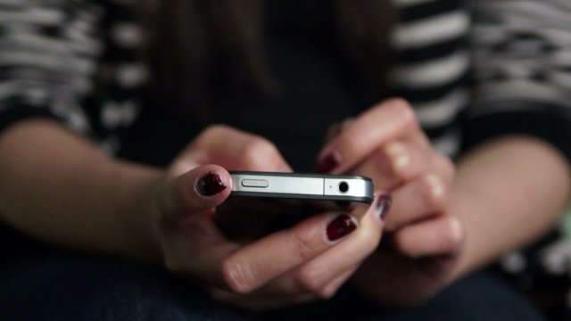 Young teen using her iPhone smartphone