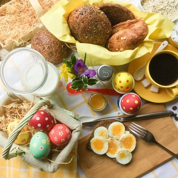 Fr&uuml;hst&uuml;ck am Ostermorgen, frohe Ostern, Fr&uuml;hst&uuml;ckstisch mit Ostereiern, Br&ouml;tchen, Kaffee