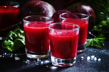 Beetroot juice in glasses on a dark background, selective focus