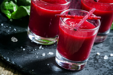 Beetroot juice in glasses on a dark background, selective focus