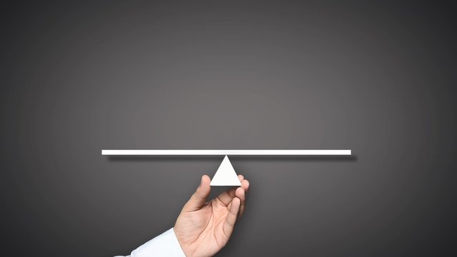 Gender equality concept. Hand holding balance with male and female figures. The female figure outweighs the male figure