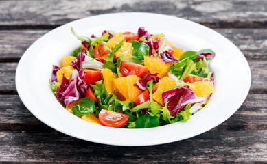 Fresh Orange, vegetables salad on wooden table.