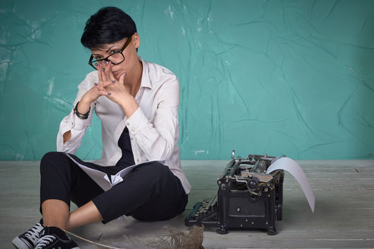 Young  business woman in work process with documents, typewriter, studio
