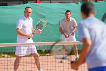 Men playing tennis doubles