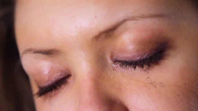 Close-up of girls tearful eyes. Smudge the ink on the face.