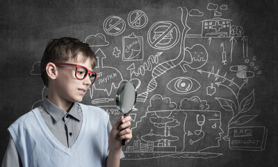 Curious school boy with magnifier