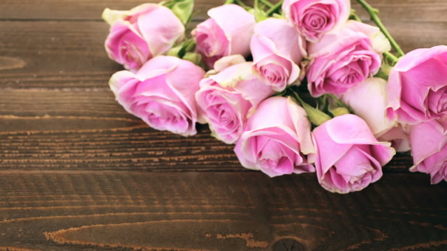 Pink roses on rustic wood table