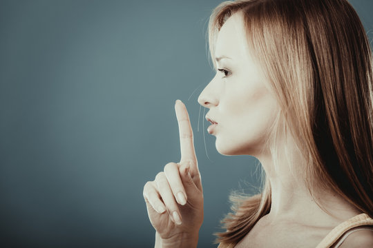 Woman asking for silence finger on lips