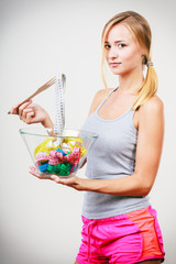 Diet. Girl with colorful measuring tapes in bowl