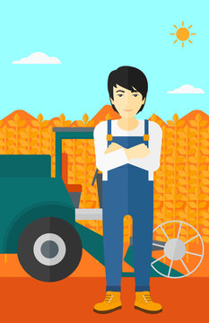 Man standing with combine on background.