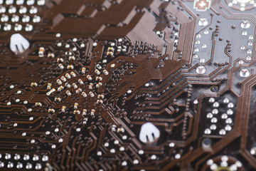 Macro closeup of a computer PCB Motherboard using brown and blac