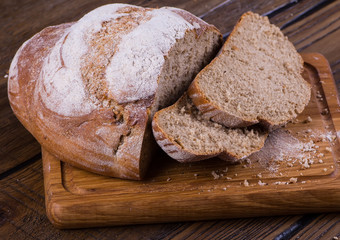 Assortment of baked bread on wooden table background
