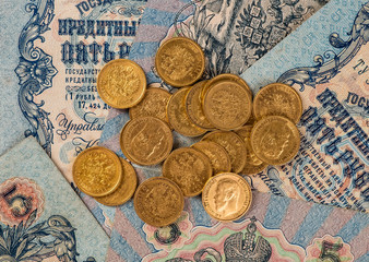 Gold and silver coins of the Russian Empire in the background ko