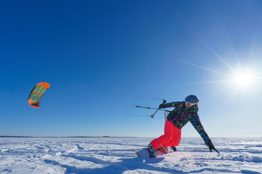 The sportsman on a snowboard runs kite