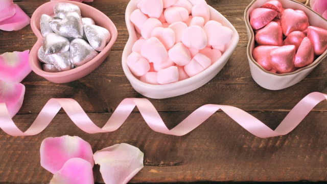 Pink roses with chocolates on rustic wood table