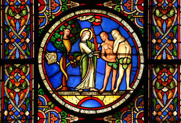 Stained glass window depicting Adam & Eve being tempted by the devil with the Angel warning them against temptation