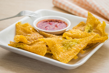 Deep fried dumplings and dipping sauce on plate