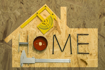 The concept of home renovation. Fixing materials and tools on a sheet of OSB, the frame in the...