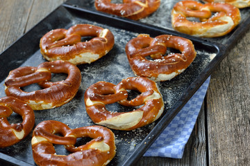 Ofenfrische handgemachte bayerische Brezen auf Backblechen - Oven fresh handmade Bavarian pretzels on a baking sheets