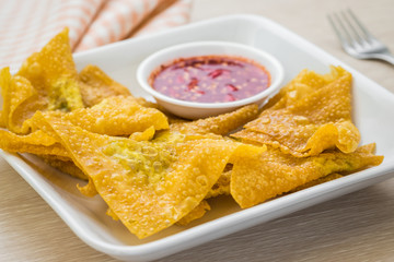 Deep fried dumplings and dipping sauce on plate