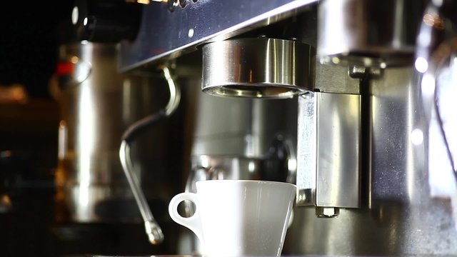 Detail of an espresso making machine and a cup.