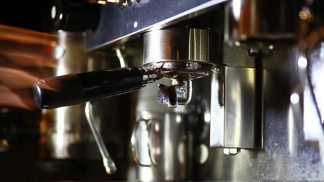 Detail of an espresso making machine and a cup.