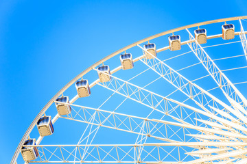 Modern ferris wheel with blue sky background.
