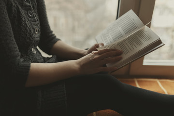 Woman read book seat on the plaid near window
