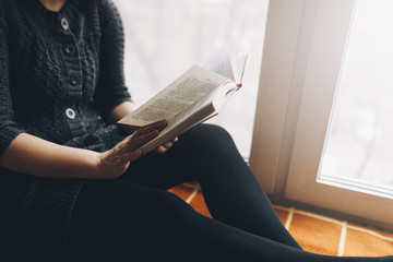 Woman read book seat on the plaid near window