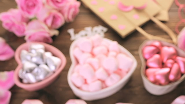 Pink roses with chocolates on rustic wood table