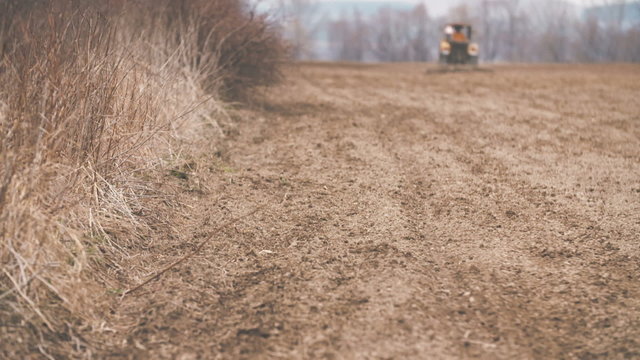 Agricultural tractor sowing and cultivating field