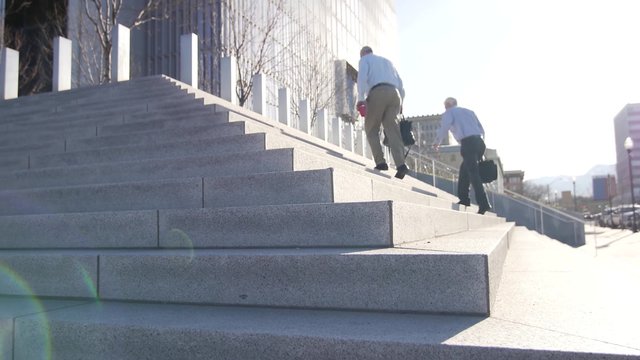 Business men walk up the stairs to the Salt Lake City Federal Courthouse.