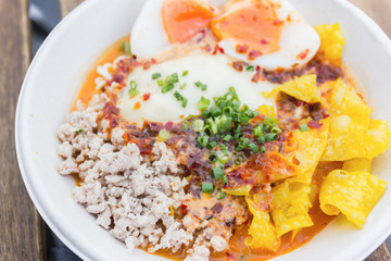 bowl of noodles with vegetables and soft boiled egg on wooden ta