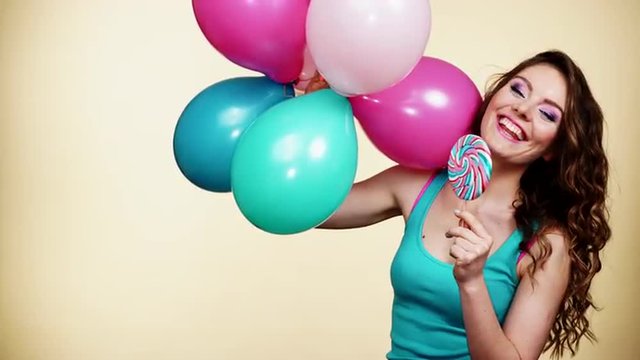 Woman smiling girl with colorful balloons and lollipop 4K