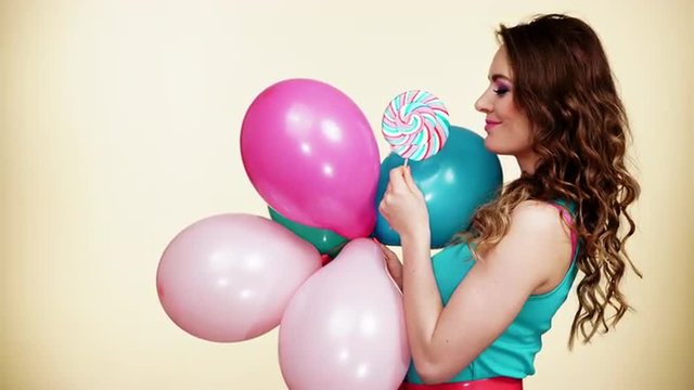 Woman smiling girl with colorful balloons and lollipop 4K