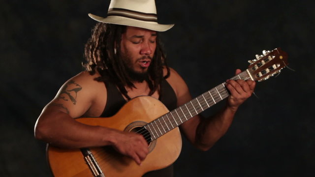 Experience the soulful melodies of a Rastafarian musician as he strums his classic guitar,transporting you to a world of reggae and blues.