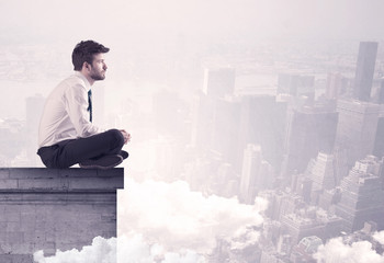 Sales person sitting on building edge in city