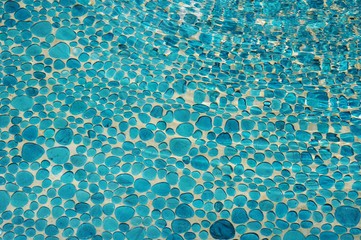 Fototapeta na wymiar Blue pebble floor under water with ripples