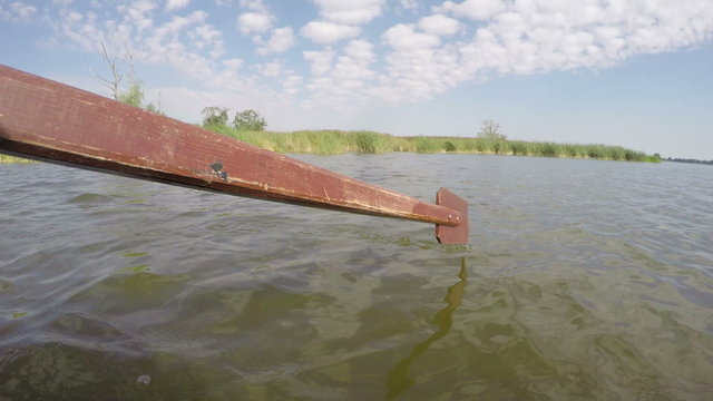 Boat rowed through the lake on sunny cloudy day, time lapse 4K