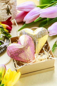 Easter: hearts in paper box, spring flowers around.