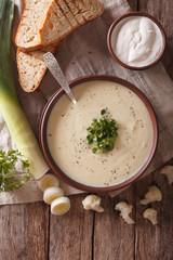 Cauliflower cream soup and ingredients close-up on. vertical top view
