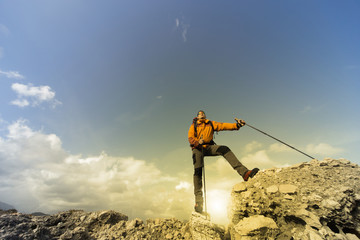Young man with backpack on a mountain top on a sunny day.
