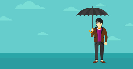 Businessman standing with umbrella.