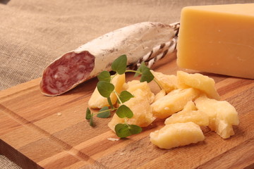 salami and cheese Parmesan on wooden cutting board