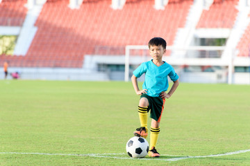Boy and football in the football grass field