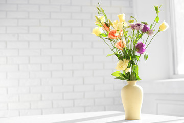 Beautiful spring flowers in vase on window background