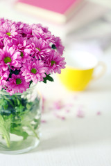 Beautiful flowers in vase on table in room